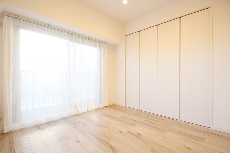 白を基調とした内装のマンションの洋室